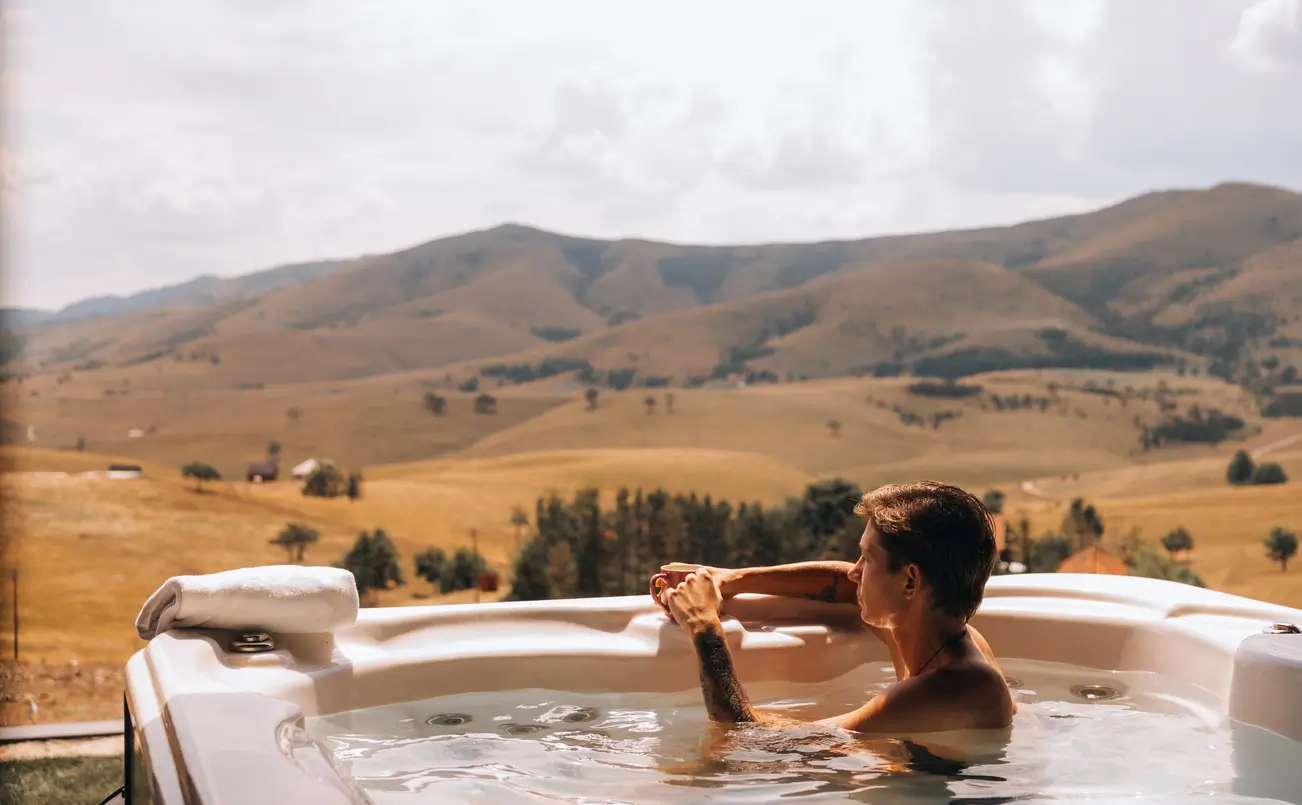 man in a hot tub in the countryside