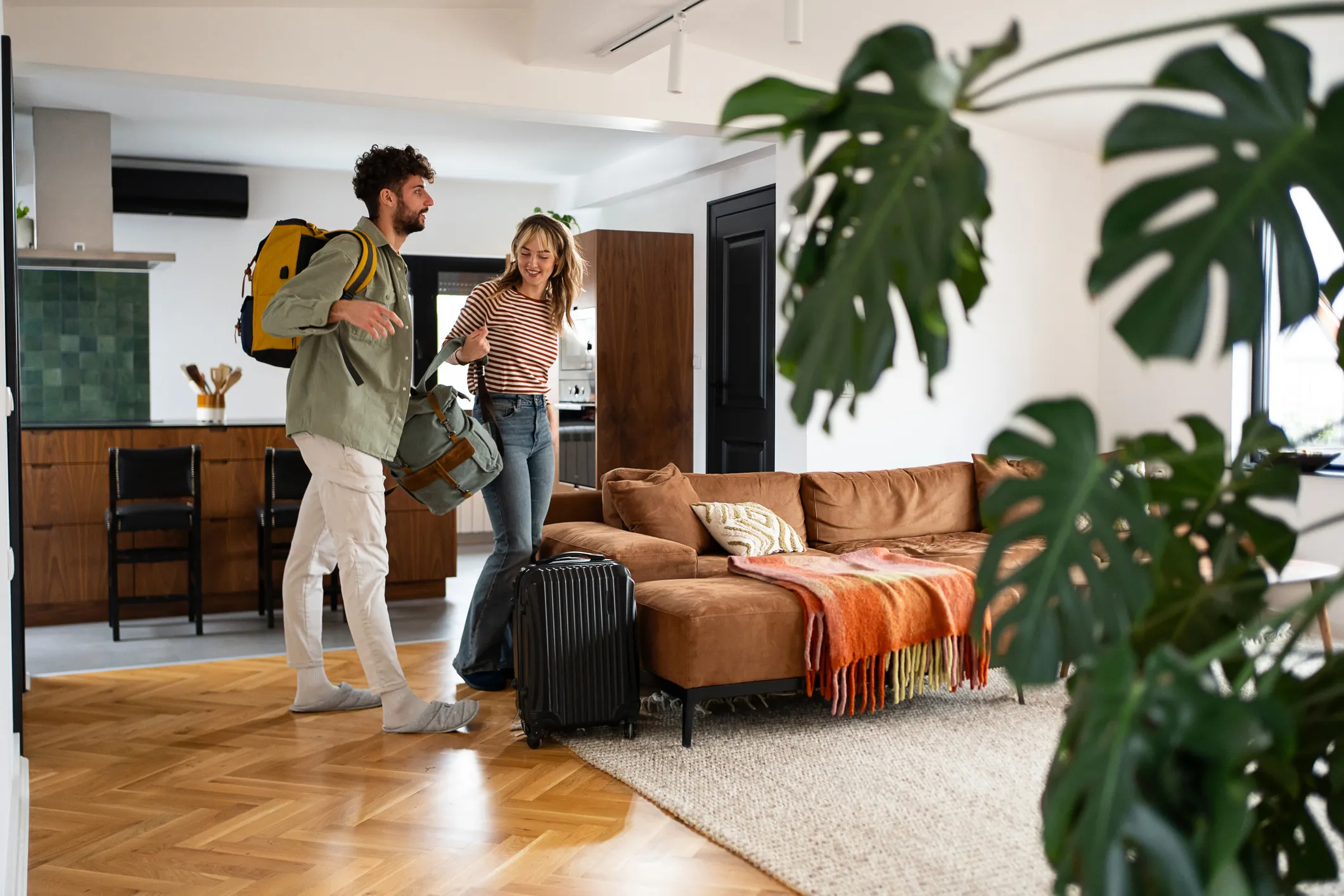 A couple bringing their suitcases into a holiday home