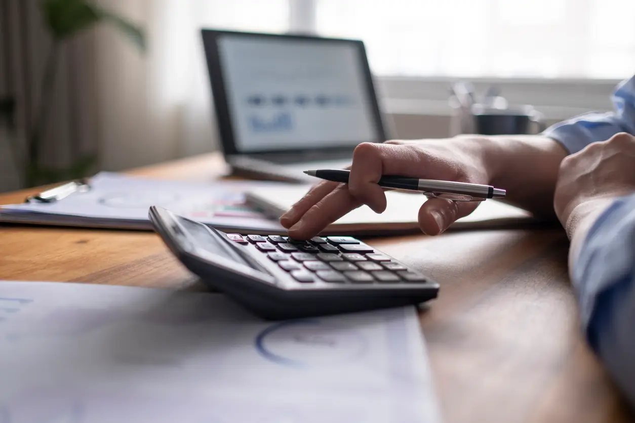 Person checking costs on their ipad and calculator