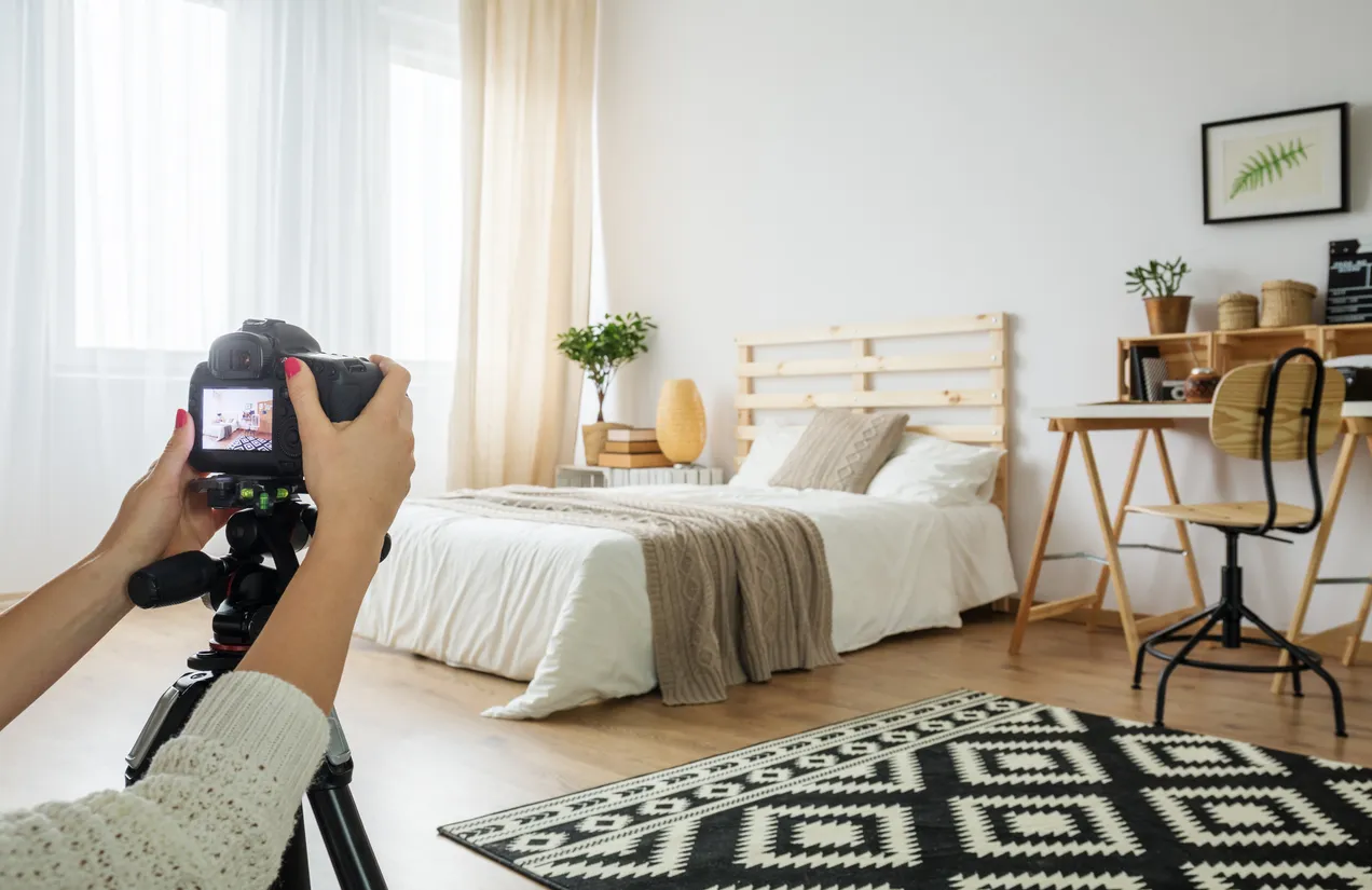 Person taking pictures of a bedroom