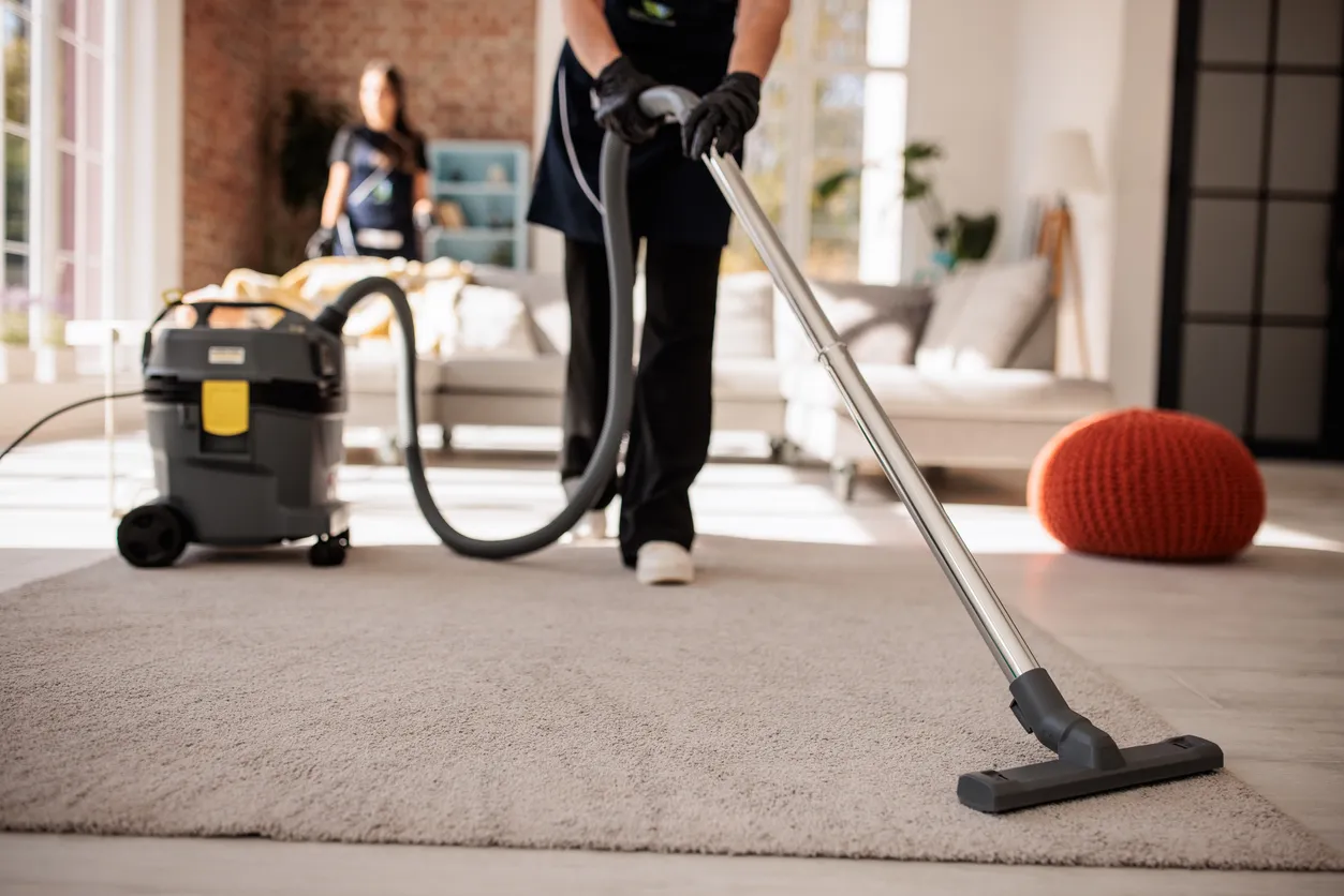 Cleaner hoovering the floor of a holiday let
