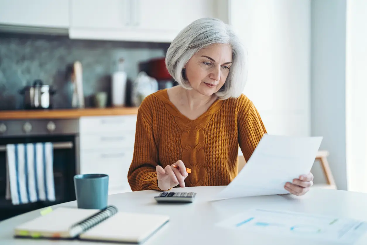 woman calculating on a kitchen table